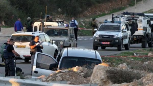 Israeli forces check cars outside of the Otniel settlement after a similar attack. (AFP/File)