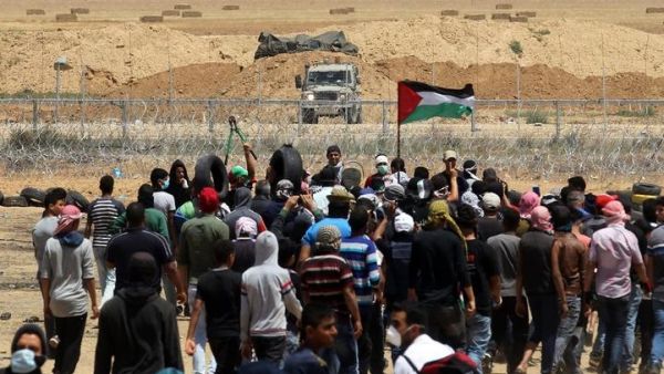 Palestinian demonstrators gesture towards Israeli forces during clashes along the Gaza border (AFP photo)