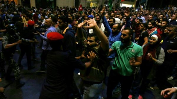 Jordanian riot police and security forces scuffle with protesters attempting to breach the area as they stand guard during a demonstration outside the Prime Minister's office in the capital Amman late on June 3, 2018. 
Khalil MAZRAAWI / AFP