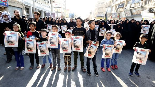 Iranian boys hold images of one of the victims Mohammad Taha Eghdami, 4, during a public funeral ceremony for those killed during an attack on a military parade on the weekend. (ATTA KENARE / AFP)