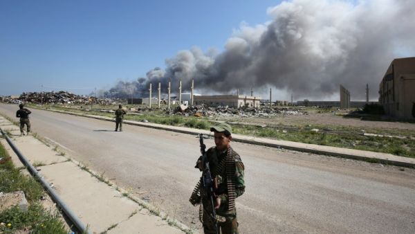 Fighters for the Popular Mobilization units in Iraq patrol a street where an attack was carried out by Daesh on February 29, 2016. (AFP/Ahmad Al-Rubaye)