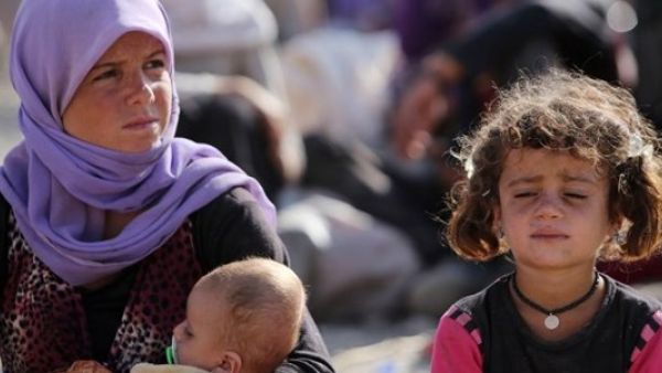 Yazidi Women in Iraq sit outside their camp. (AFP)