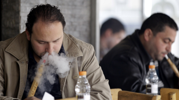 Men smoke sheesha at an Amman cafe in February 2014. (photo credit: AFP/Khalil Mazraawi)