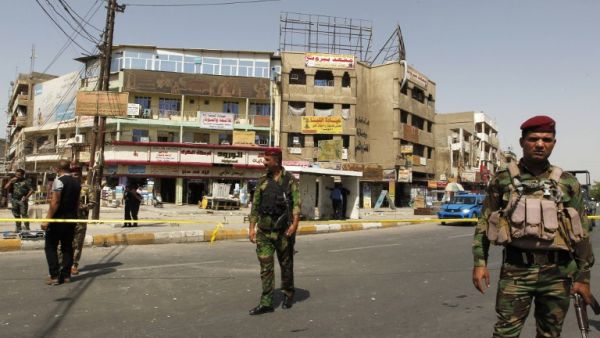 Iraqi security forces stand guard at the site of a suicide bomb attack at a market in the Baghdad Jadida neighborhood in the east of the capital on September 27, 2016. (AFP/Sabah Arar)