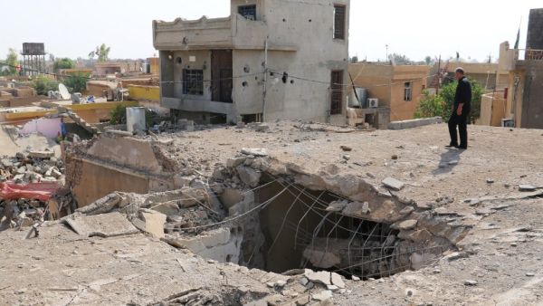 An Iraqi man stands on top of a damaged building on October 27, 2016, a few days after an air strike hit a Shia place of worship in the Iraqi town of Daquq, south of Kirkuk. (AFP/Marwan Ibrahim)