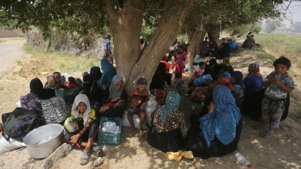 Displaced Iraqis, who fled the al-Falahat village west of Fallujah due to fighting between Iraqi government forces and Daesh, wait to receive food and aid at the village of al-Azraqiyah, on June 4, 2016. (AFP/Ahmad al-Rubaye)