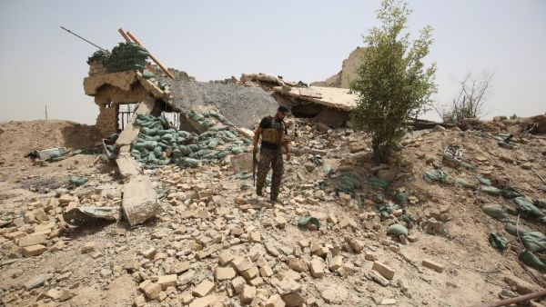 A member of the Iraqi government forces walks amid the rubble of a destroyed building on the front line near the village of al-Azraqiyah, northwest of the city of Fallujah, on June 5, 2016. (AFP/Ahmad al-Rubaye)