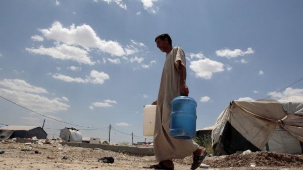 Abu Shiab carries water on May 31, 2016 at the Alexanzan camp in the Dora neighburhood outside of Baghdad where he is taking shelter with his family after they were displaced from the Jbeil, a village near Fallujah due to clashes between pro-government forces and Daesh. (AFP/Sabah Arar) Abu Shiab carries water on May 31, 2016 at the Alexanzan camp in the Dora neighburhood outside of Baghdad where he is taking shelter with his family after they were displaced from the Jbeil, a village near Fallujah due to clashes between pro-government forces and Daesh. (AFP/Sabah Arar)