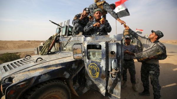 Iraqi forces receive fruits on a road near in the village of Arbid on the southern outskirts of Mosul on November 9, 2016, during the ongoing military operation to retake Mosul from Daesh. (AFP/Ahmad al-Rubaye)
