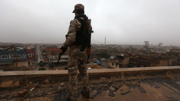 An Iraqi security member stands guard as Iraqi Christians attend a Christmas Eve service at the Saint John's church in the town of Qaraqosh, 30 km east of Mosul, on December 25, 2016. (AFP/Safin Hamed)