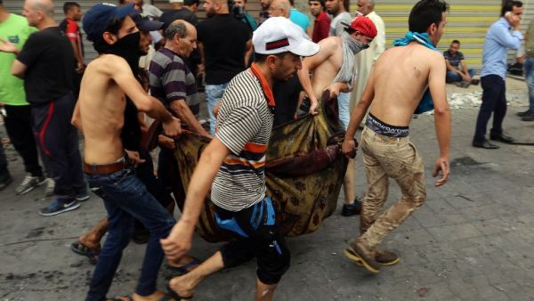 Iraqis evacuate a body from the site of a suicide car bombing claimed by the Islamic State group on July 3, 2016 in Baghdad's central Karrada district. (AFP/Sabah Arar)