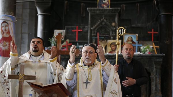 Iraqi clergy celebrate Palm Sunday in a church in Qaraqosh, near Mosul, 9 April 2017. (AFP/Ahmad Gharabli)