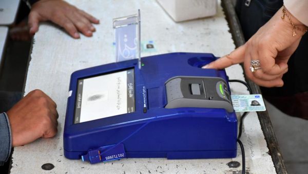 An Iraqi voter has her biometric voting card checked with her fingerprint upon arriving at a poll station for the parliamentary elections in the northern multi-ethnic city of Kirkuk on May 12, 2018. (Marwan Ibrahim/ AFP)