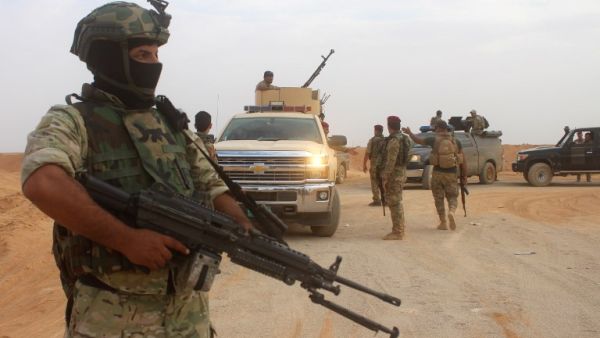 Iraqi forces are seen outside the town of Akashat, northwest of the al-Anbar province, as they prepare a military operation to push out ISIS (Moadh Al-Dulaimi/AFP)