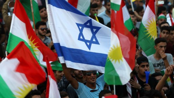 Iraqi Kurds fly an Israeli flag and Kurdish flags during an event to urge people to vote in the upcoming independence referendum (Safin Hamed/AFP)