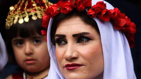 Wearing traditional Yazidi clothes, holding candles and paraffin lamps, Yazidis gather in the holy town of Lalish.(AFP)