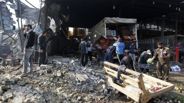 Iraqis salvage vegetables from the site of an attack at Baghdad's main vegetable market on January 8, 2017. (AFP/Sabah Arar)