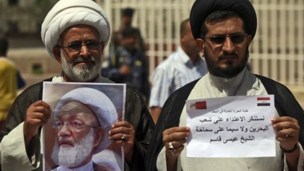 Iraqi Shiite clerics hold a picture of top Bahraini Shiite cleric Isa Qassim during a demonstration in front of the Bahraini consulate in Najaf on May 24, 2017 in solidarity with the Bahraini Shiite opposition and with the leading cleric. (Haidar Hamdani/AFP)