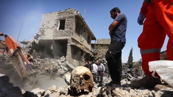 Iraqi civil defense and rescue workers search for the bodies of victims under the rubble of buildings in western Mosul's Zanjili district on July 26, 2017 (Safin Hamed/AFP)