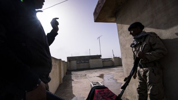 Two Iraqi army soldiers take position on the rooftop of a house during a battle against the Islamic State (IS) group near the Fourth Bridge over the Tigris River connecting eastern and western Mosul on January 10, 2017. (AFP/Dimitar Dilkoff)