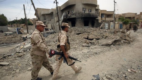 Members of the Iraqi forces patrol streets in the western neighborhood of Tamuz in Mosul on May 23, 2017, after the area was retaken during the ongoing offensive against Islamic State (IS) group fighters. (AFP/Ahmad al-Rubaye)