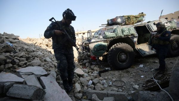Iraqi forces stand next to a barricade at the frontline of the Old City of Mosul on March 25, 2017, during the government forces' ongoing offensive to retake the city from Daesh fighters. (AFP/Ahmad al-Rubaye)