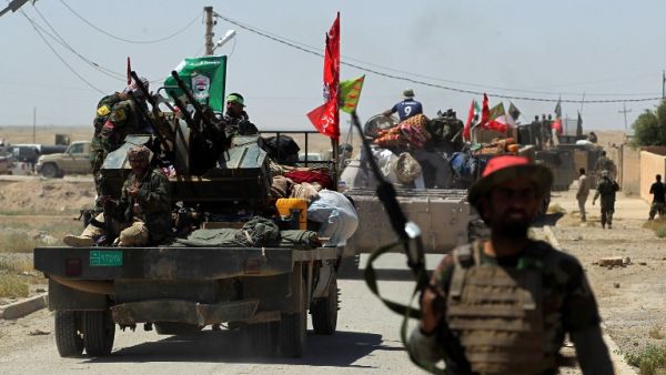 Members of the Iraqi pro-government Hashed al-Shaabi (Popular Mobilisation) paramilitary forces gather in a street in the modern town of Hatra, near the eponymous UNESCO-listed ancient city, southwest of the northern city of Mosul, on April 28, 2017. (AFP/Ahmad al-Rubaye)