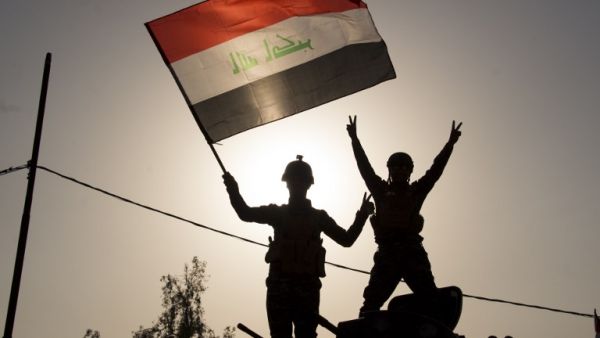 Iraq's federal police members wave Iraq's national flag as they celebrate in the Old City of Mosul on July 9, 2017 after the government's announcement of the "liberation" of the embattled city. (Fadel Senna/AFP)