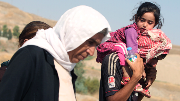Displaced Iraqi families from the Yazidi community cross the Iraqi-Syrian border at the Fishkhabur crossing, in northern Iraq, on August 13, 2014.(AFP/Ahmad Al-Rubaye)