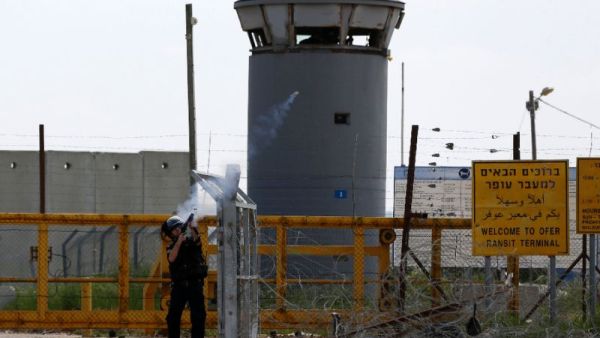 An Israeli guard fires tear gas at Palestinian protesters outside of Ofer prison. (AFP/File)