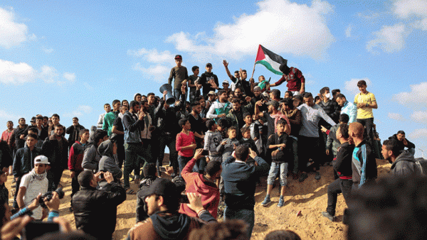Palestinian protestors wave their national flag during a demonstration near the border with Israel. (AFP/ File Photo)