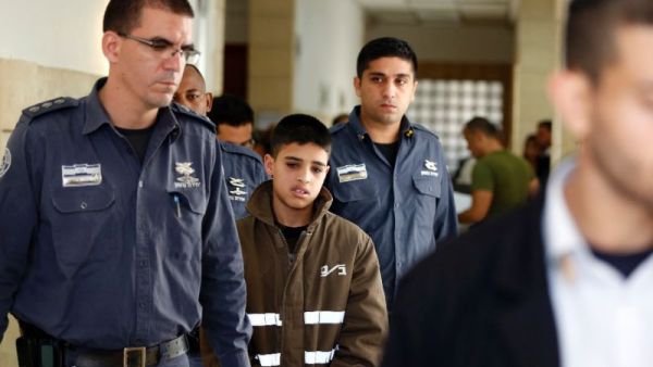Ahmed Manasra, a 13-year old Palestinian accused of taking part in the stabbing of two Israelis earlier this month, is escorted by Israeli security during a hearing at a Jerusalem court on October 30, 2015. (AFP/Ahmad Gharabli)
