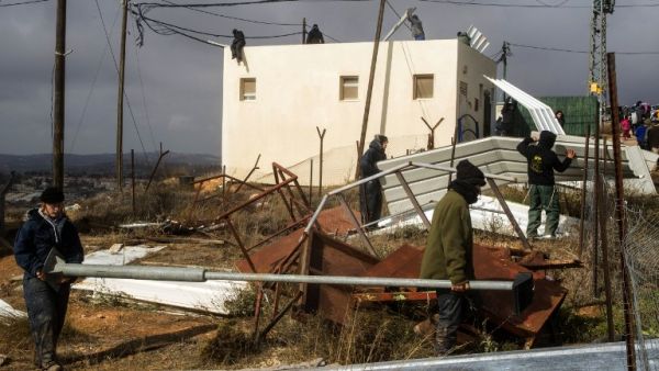 Israeli youth settlers block the entrance of the settlement outpost of Amona on December 15, 2016, which was established in 1997, in the Israeli-occupied West Bank. (AFP/Jack Guez)