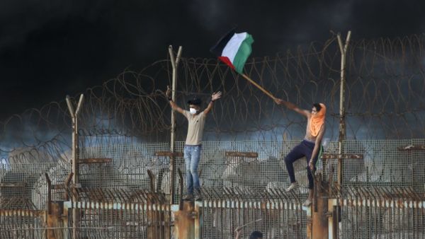 Palestinian protestors place their national flag on a metal structure during a demonstration on the beach near the maritime border with Israel, in the northern Gaza Strip, on October 8, 2018. (Said KHATIB / AFP)