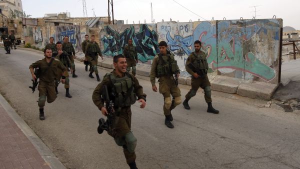 Israeli soldiers run down a road in Hebron, in the occupied West Bank, April 12 2017. (AFP/Hazem Bader)