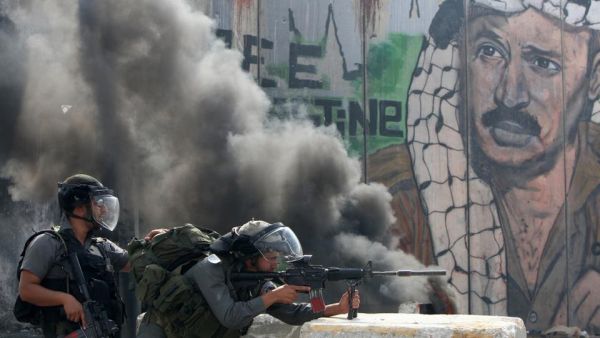 Israeli soldiers attack Palestinian protestors at a checkpoint outside occupied Jerusalem (AFP)