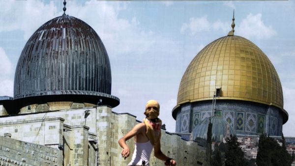 A Palestinian protester stands in front of a mural covered in an image of the Dome of the Rock during clashes between demonstrators and Israeli security forces at the Huwara checkpoint, south of Nablus. (AFP) 