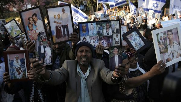 Ethiopian Israelis hold pictures of relatives as they protest in front of the Knesset in Jerusalem. (AFP/ File Photo)