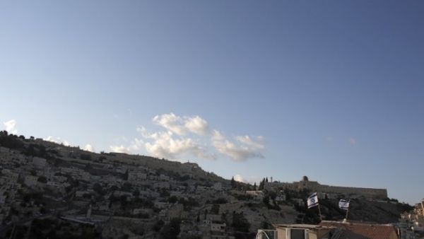 Israeli flags flying above the home of Palestinian family Abu Snineh, whose building was taken over by Jewish residents in the Silwan neighborhood of East Jerusalem, August 30, 2015. (AFP/Ahmad Gharabli)