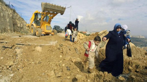 Palestinians walk along a demolished road by Israel leading to the village of Al Walaja in the West Bank. (Musa Al Shaer/ AFP)