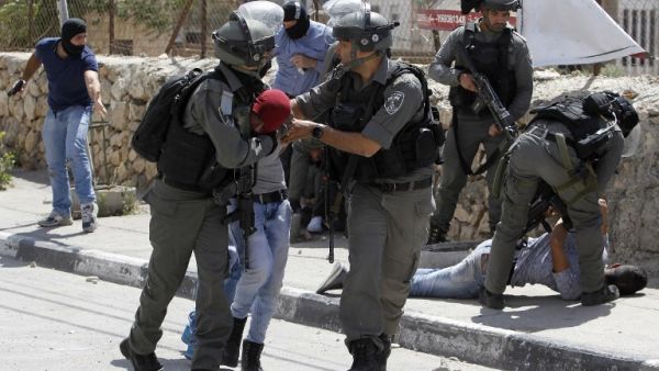Israeli borderguards and undercover police detain a Palestinian protester during clashes at the entrance of the West Bank city of Bethlehem on May 19, 2017. (AFP/Musa al Shaer)