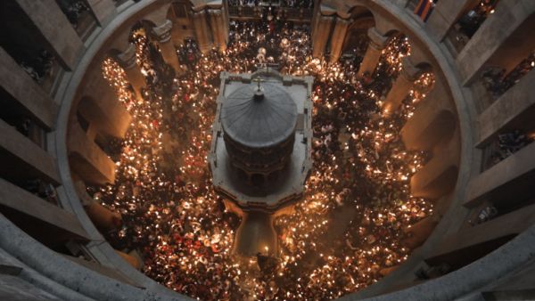 Christian Orthodox worshippers hold up candles during the ceremony of the "Holy Fire" as thousands gather in the Church of the Holy Sepulchre in Jerusalem's Old City, on April 15, 2017, during Orthodox Easter ceremonies. (AFP/Menahem Kahana)