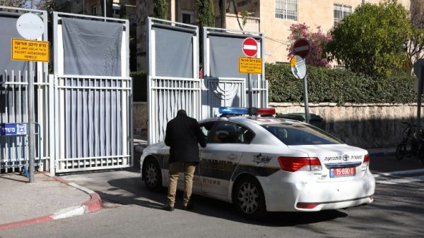 An Israeli police car is seen at the entrance to the residence of Israeli Prime Minister Benjamin Netanyahu as members of the media wait for the arrival of police investigators on January 2, 2017. (AFP/Gali Tibbon)