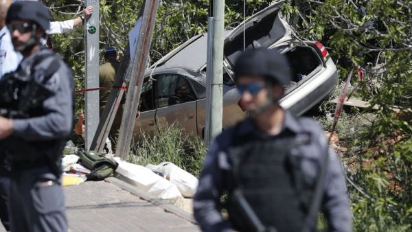 Israeli security forces stand guard at the site of a car ramming attack outside the Israeli settlement of Ofra, north of the Palestinian city of Ramallah, on April 6, 2017. (AFP/Thomas Coex)
