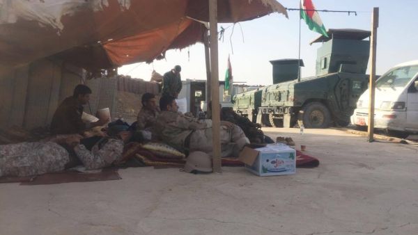 Peshmerga fighters sit together in the shade. (Al Bawaba/ Adam Lucente)