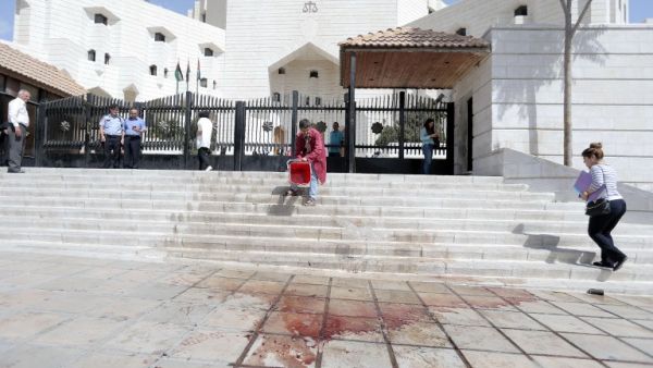 A man cleans the blood of prominent Jordanian writer Nahed Hattar after he was shot dead outside a court in Amman on Sept. 25, 2016, where he was facing charges for sharing a cartoon deemed offensive to Islam. (AFP/Ahmad Alalameen)