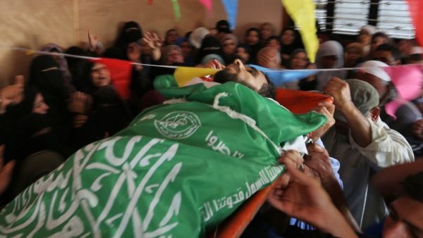 Mourners carry the body of Mohammed Dwedar a 27 year-old Palestinian, killed by Israeli fire along the Gaza border/AFP
