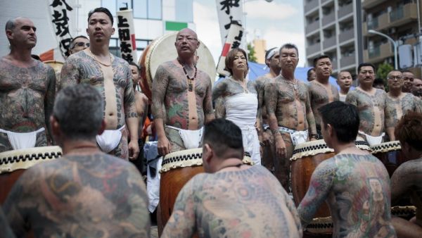 Participants pose to show their traditional Japanese tattoos (Irezumi), related to the Yakuza, during the annual Sanja Matsuri festival in the Asakusa district of Tokyo /AFP