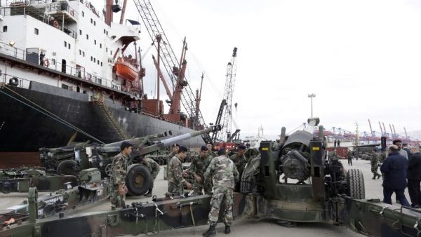 Lebanese soldiers stand next to M198 155mm howitzers upon the arrival of a shipment of US weapons at the Beirut port on February 8, 2015. (AFP/Anwar Amro)
