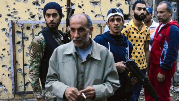 Members of the joint Palestinian security force walk in Ain al-Hilweh camp, Lebanon's largest Palestinian refugee camp, near the southern coastal city of Sidon, on April 12, 2017, after clashes that took place earlier in the week between an extremist group and the security force. (AFP/Stringer)